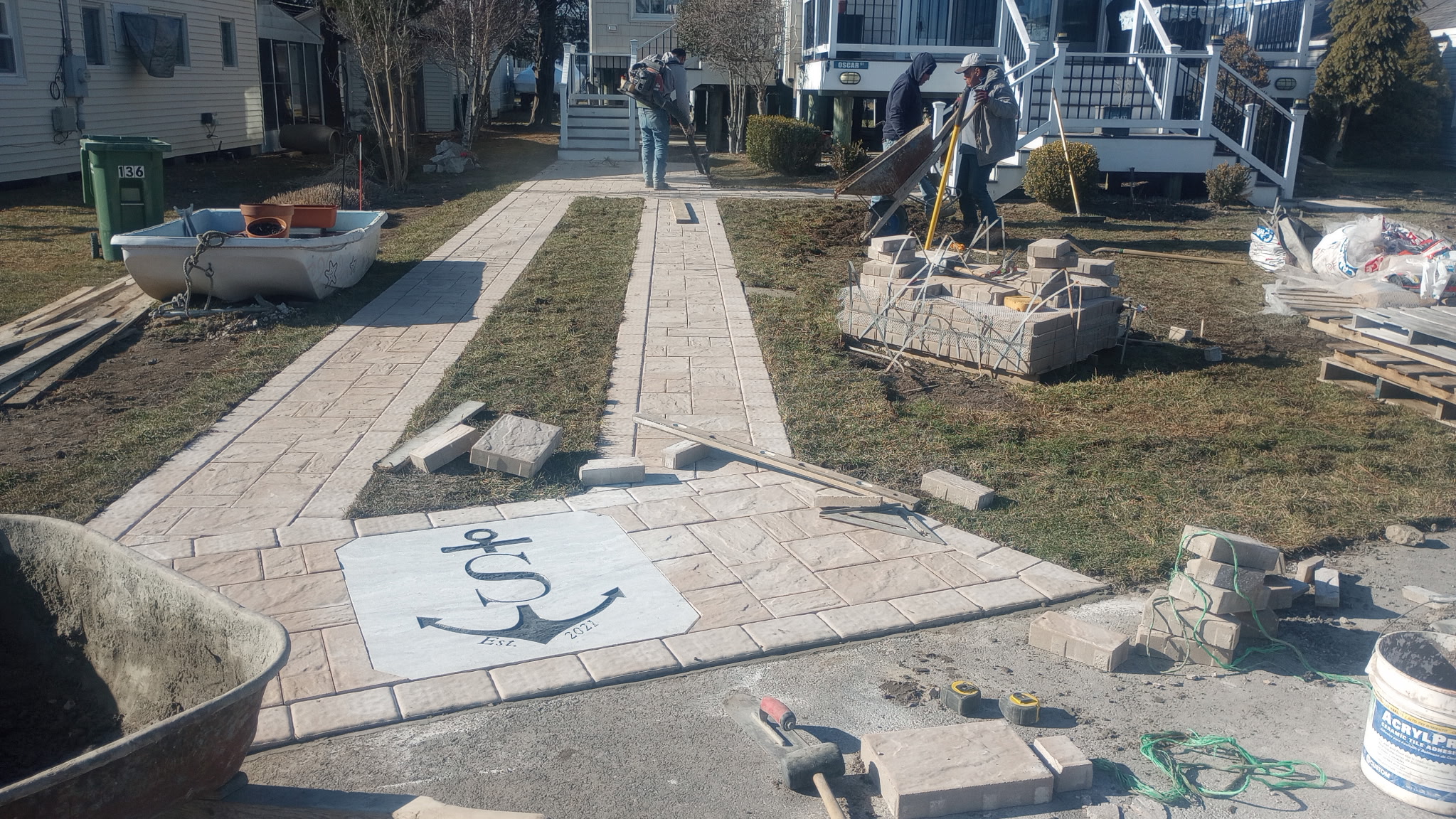 Custom anchor monogram inlay being installed into a stamped concrete walkway
