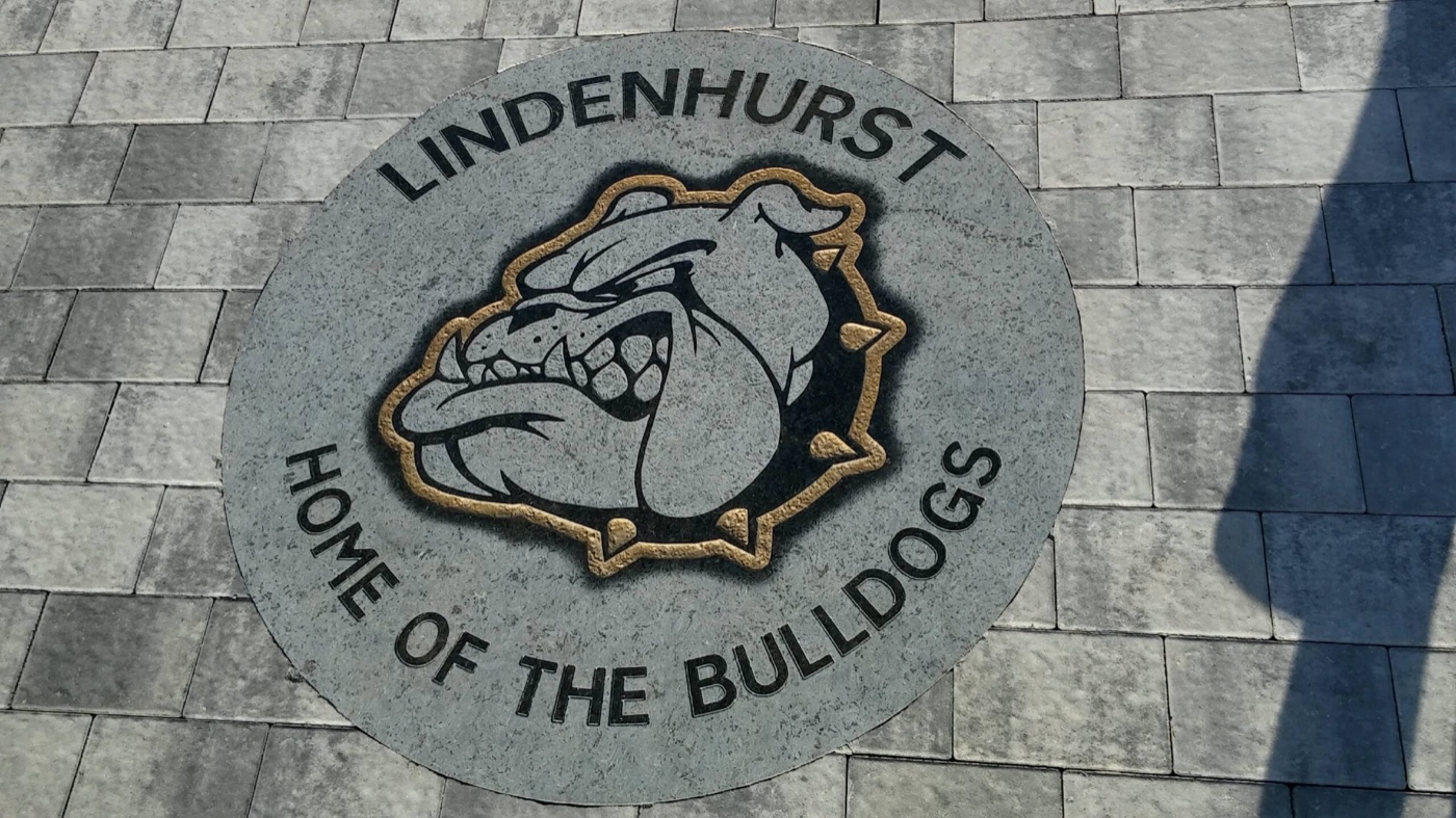 Lindenhurst Home of the Bulldogs engraved stone medallion set into a paver walkway