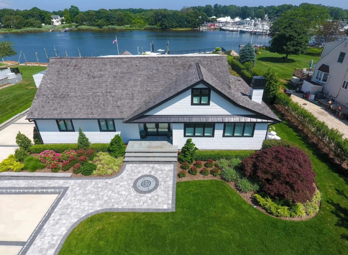 Aerial view of waterfront home with compass inlay on the entry walkway