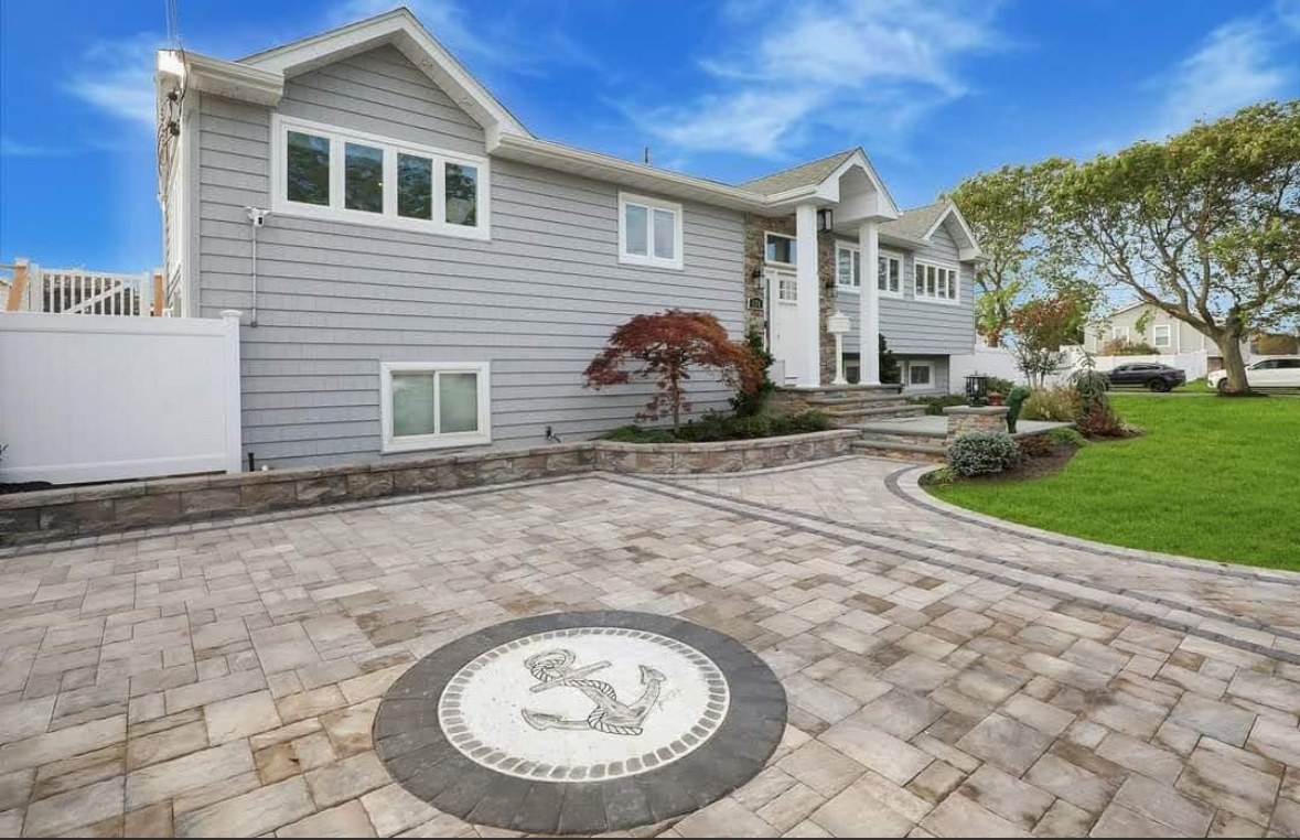 Custom natural stone inlay set into a paver driveway