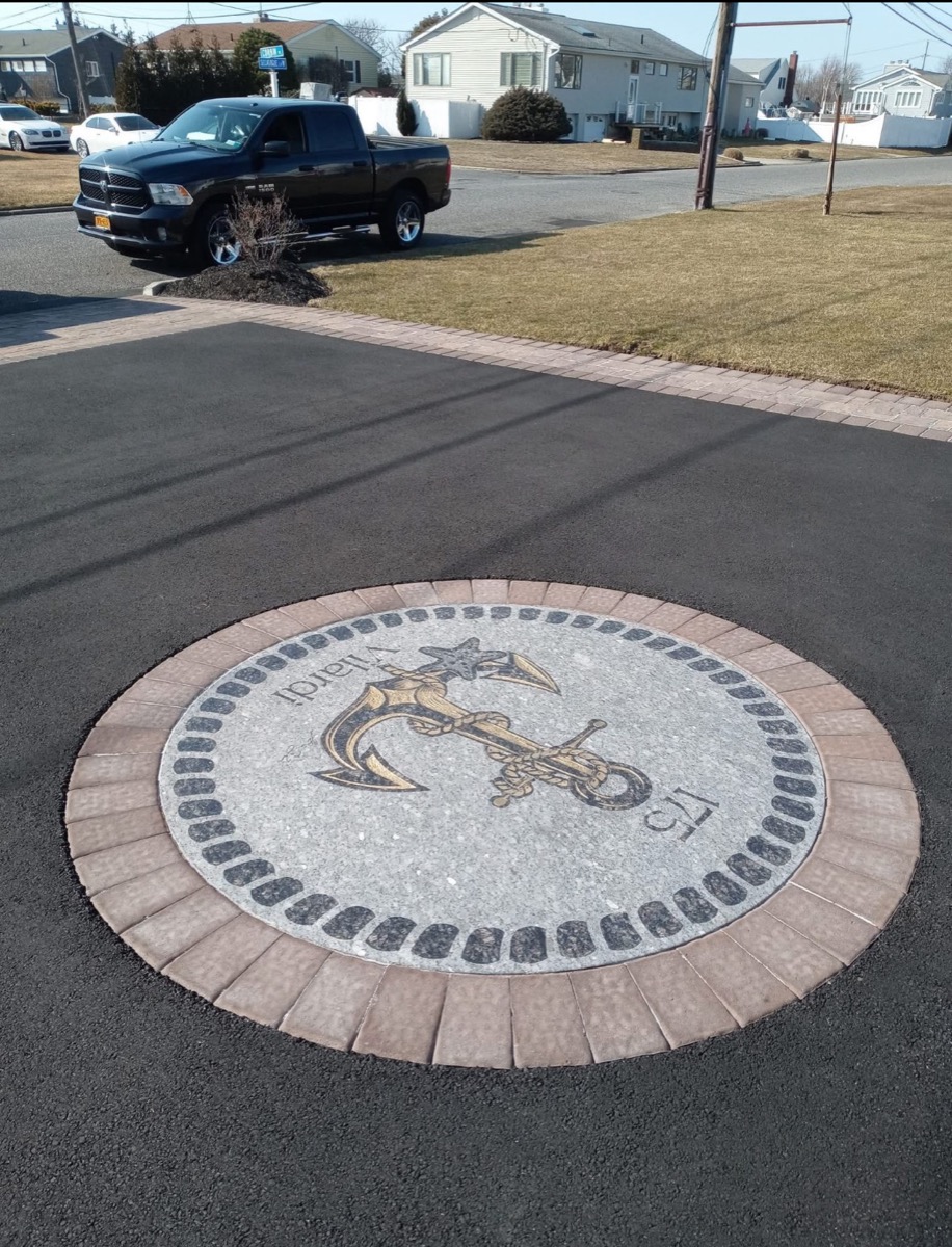 Custom gold anchor and starfish medallion inlaid into an asphalt driveway