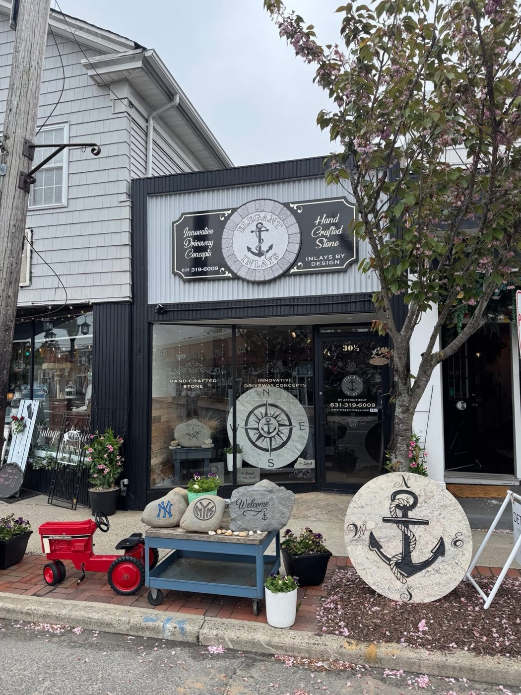 The Elegant Inlays showroom at 30 1/2 Railroad Ave in Sayville, with hand-carved stone inlays and engraved rocks displayed out front