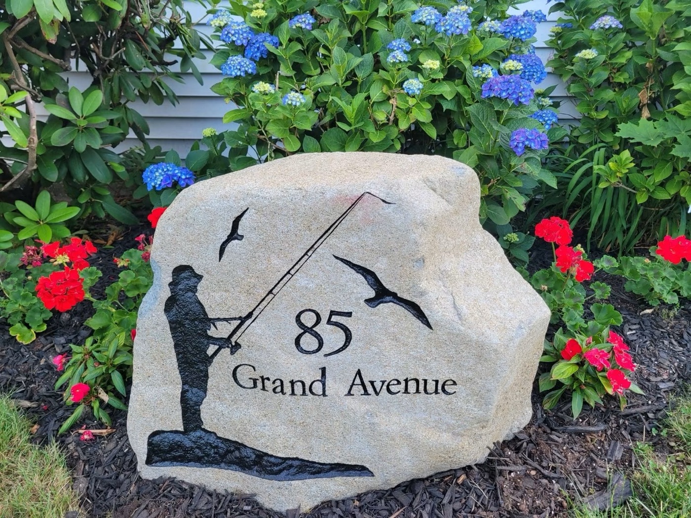 Engraved address rock reading 85 Grand Avenue with a fisherman and seagulls design