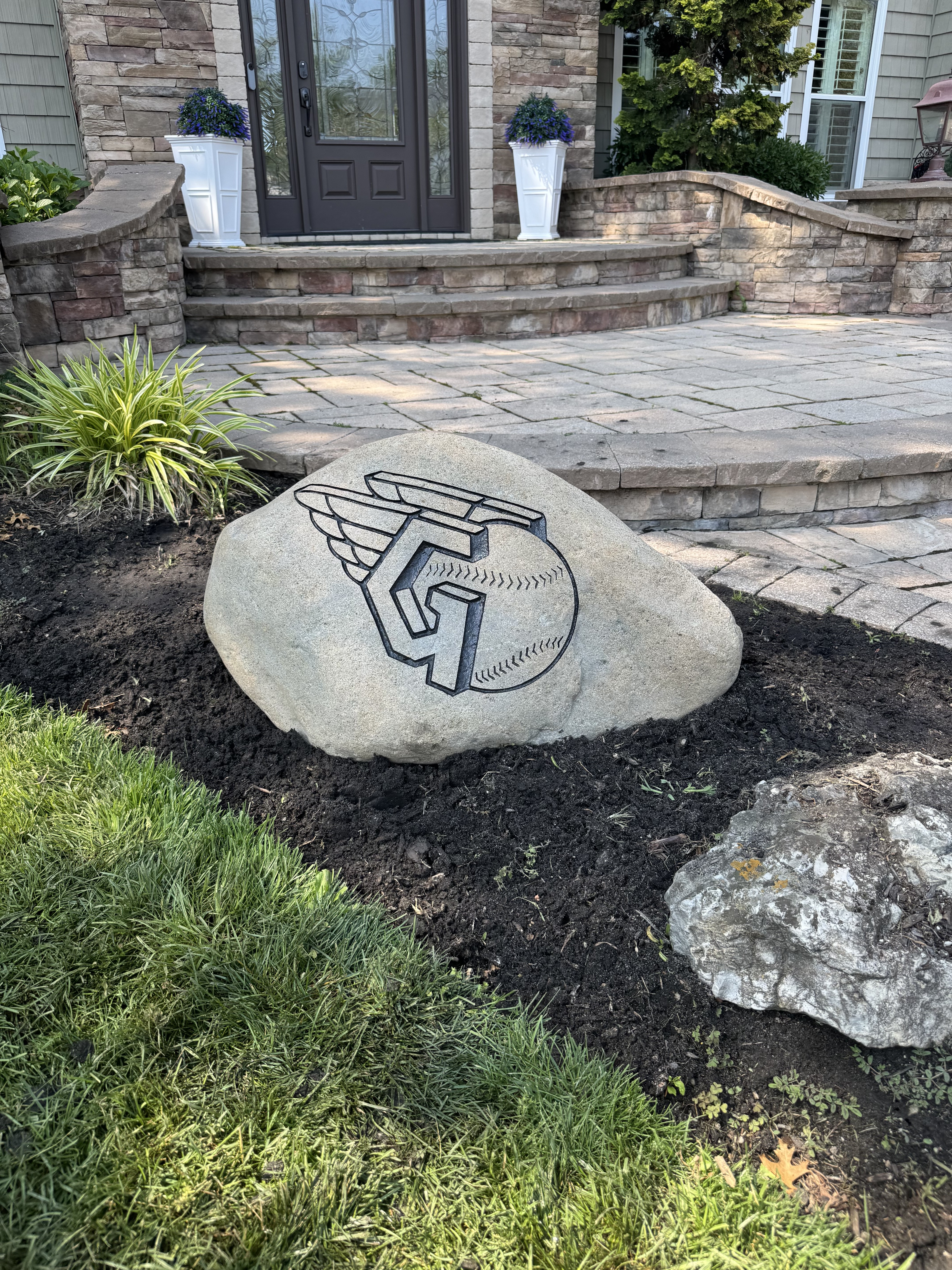 Cleveland Guardians logo engraved rock beside a front entry