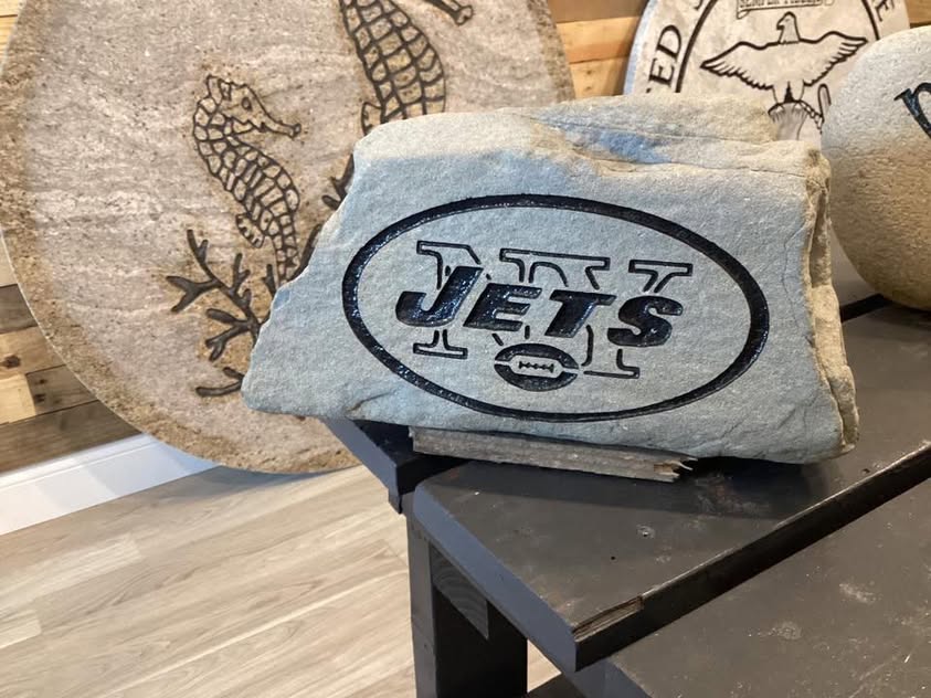 New York Jets engraved rock beside a seahorse design rock