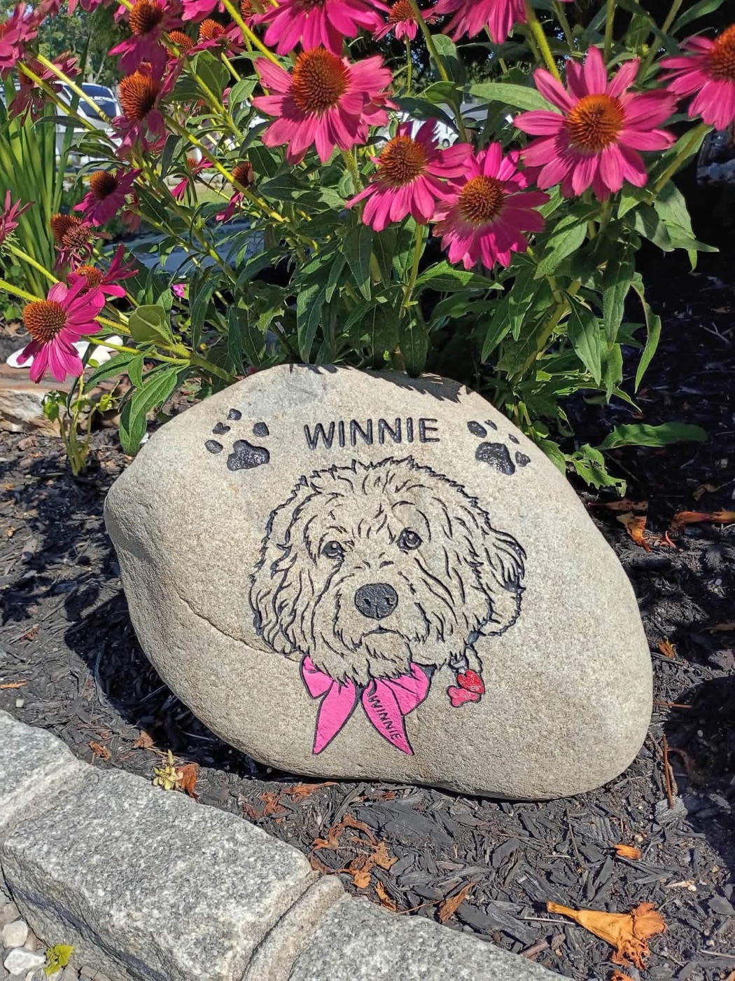Pet memorial rock engraved with a dog portrait and pink bandana, reading Winnie