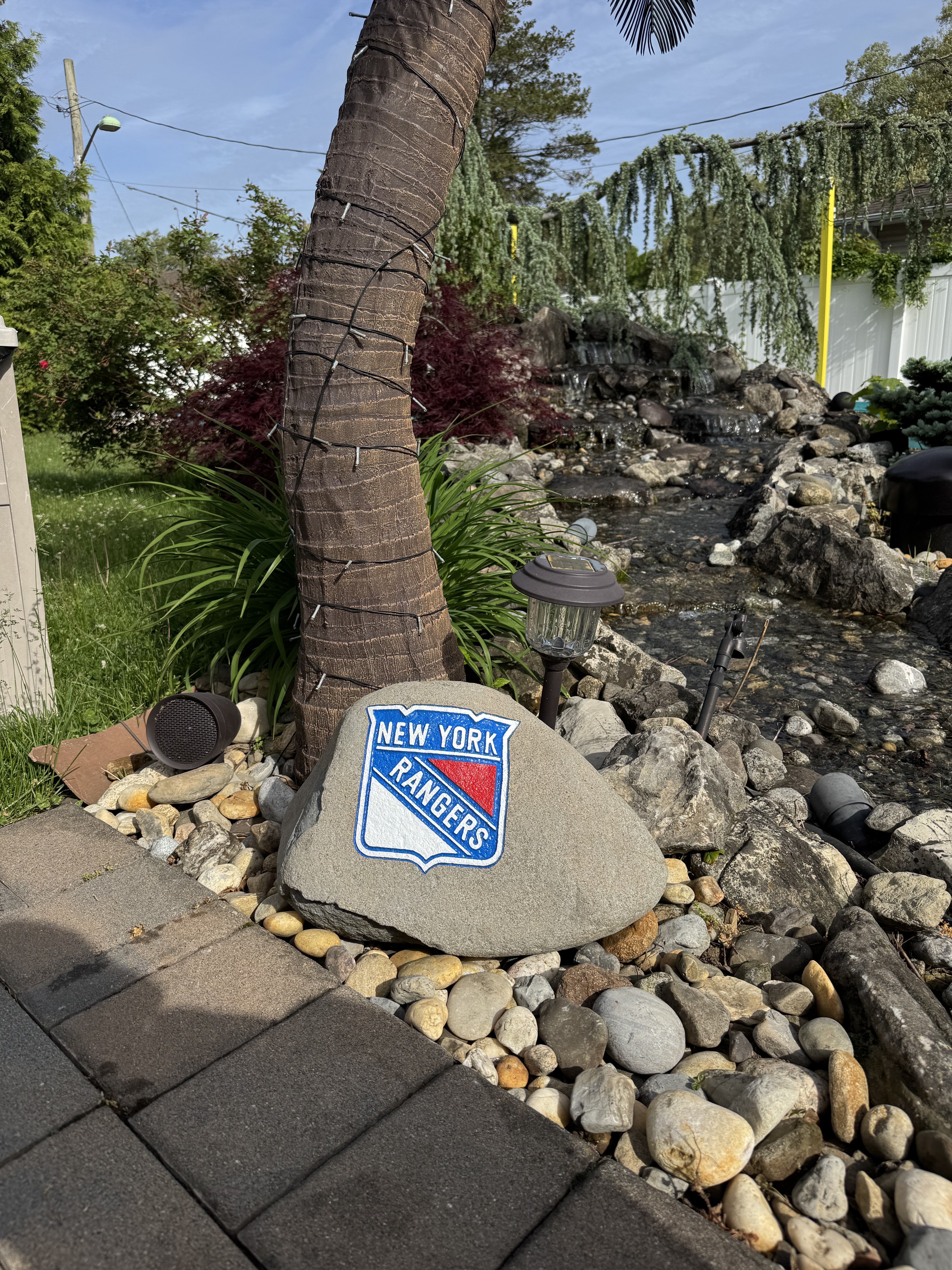 New York Rangers full color crest engraved rock beside a water feature