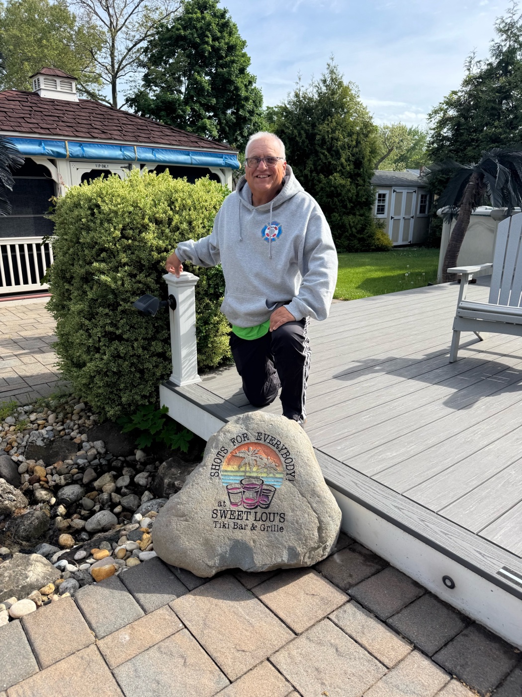 Custom engraved rock reading Shots for Everybody at Sweet Lou's Tiki Bar and Grille, set beside a backyard deck